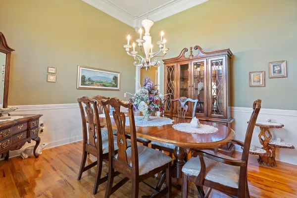 a view of a dining room with furniture a chandelier and wooden floor