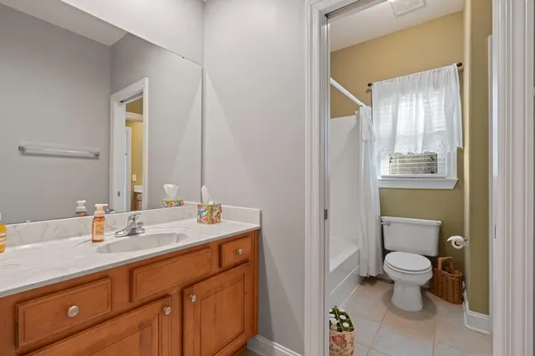 a spacious bathroom with a granite countertop sink a toilet and a mirror