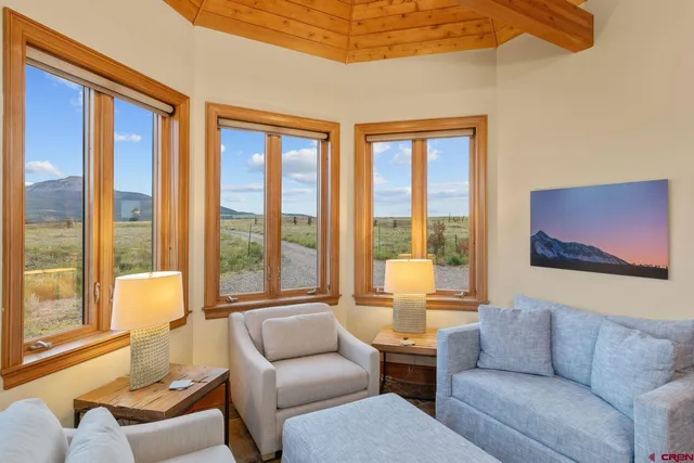 a living room with furniture and floor to ceiling windows