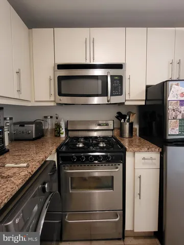 a kitchen with stainless steel appliances granite countertop a stove and a microwave