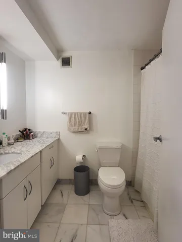 a spacious bathroom with a toilet sink and mirror