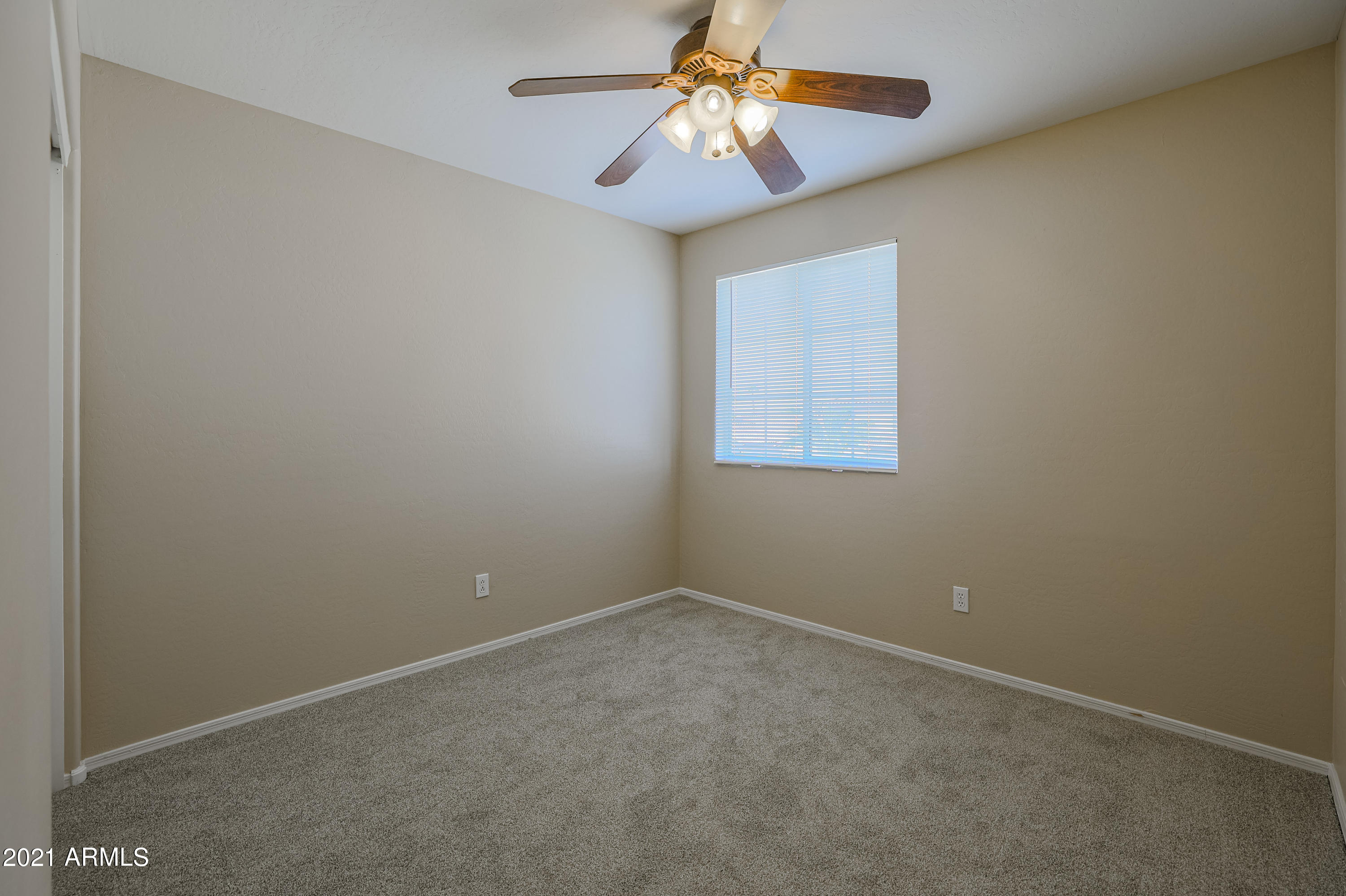 4349 North 111th Lane Phoenix, AZ 85037 - Photo 14 of 18 an empty room with a window and a fan