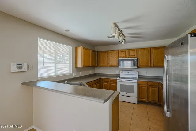 a kitchen that has a sink cabinets stainless steel appliances and a window