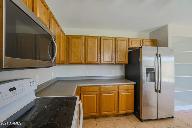 a kitchen with a refrigerator and cabinets