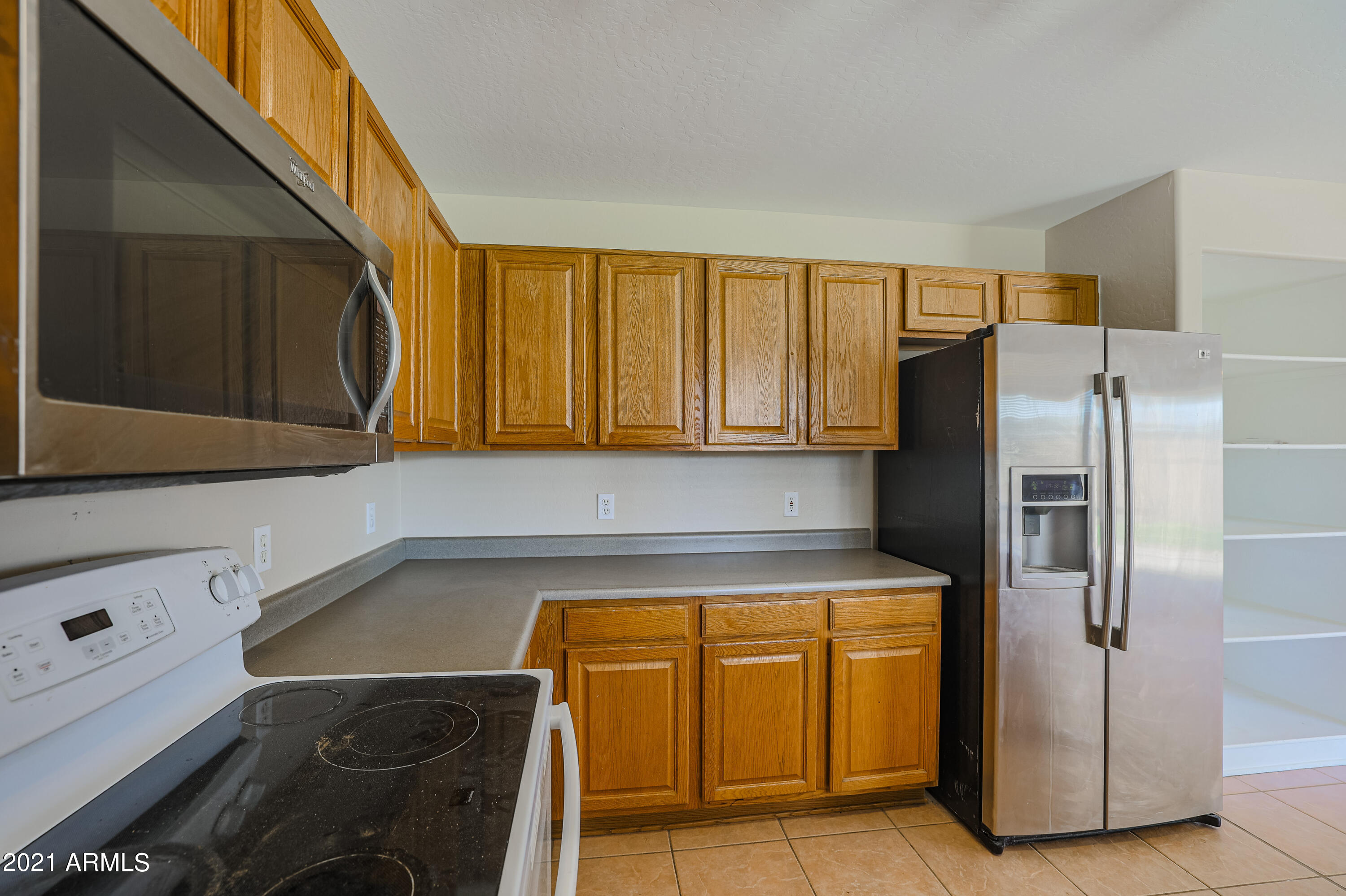 4349 North 111th Lane Phoenix, AZ 85037 - Photo 6 of 18 a kitchen with a refrigerator and cabinets