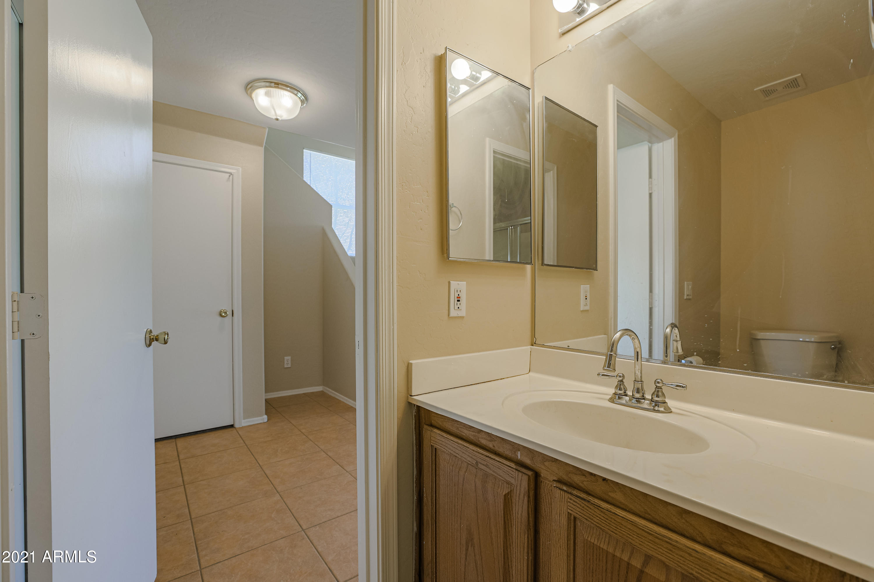 4349 North 111th Lane Phoenix, AZ 85037 - Photo 9 of 18 a bathroom with a sink and a mirror