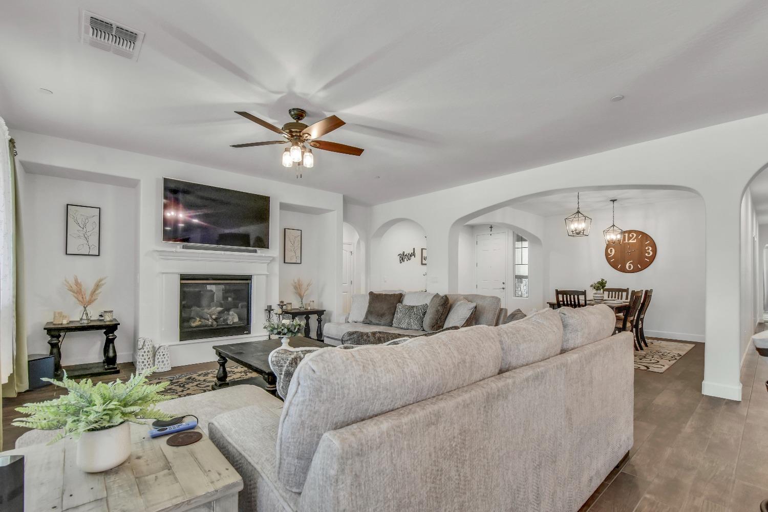 400 Ridge Creek Estates Way Dinuba, CA 93618 - Photo 16 of 49 a living room with furniture a fireplace and a flat screen tv