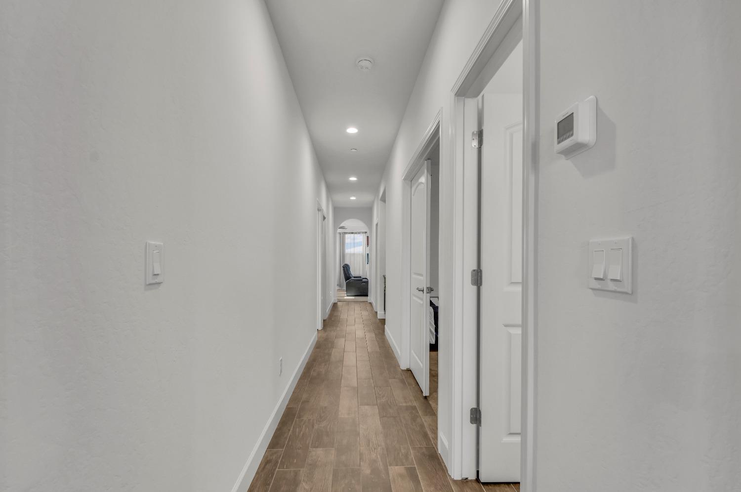 400 Ridge Creek Estates Way Dinuba, CA 93618 - Photo 18 of 49 a view of a hallway with wooden floor and a bathroom