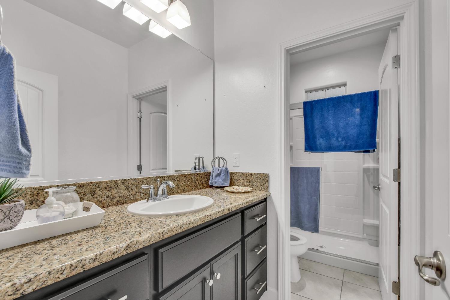 400 Ridge Creek Estates Way Dinuba, CA 93618 - Photo 23 of 49 a bathroom with a granite countertop sink and a mirror