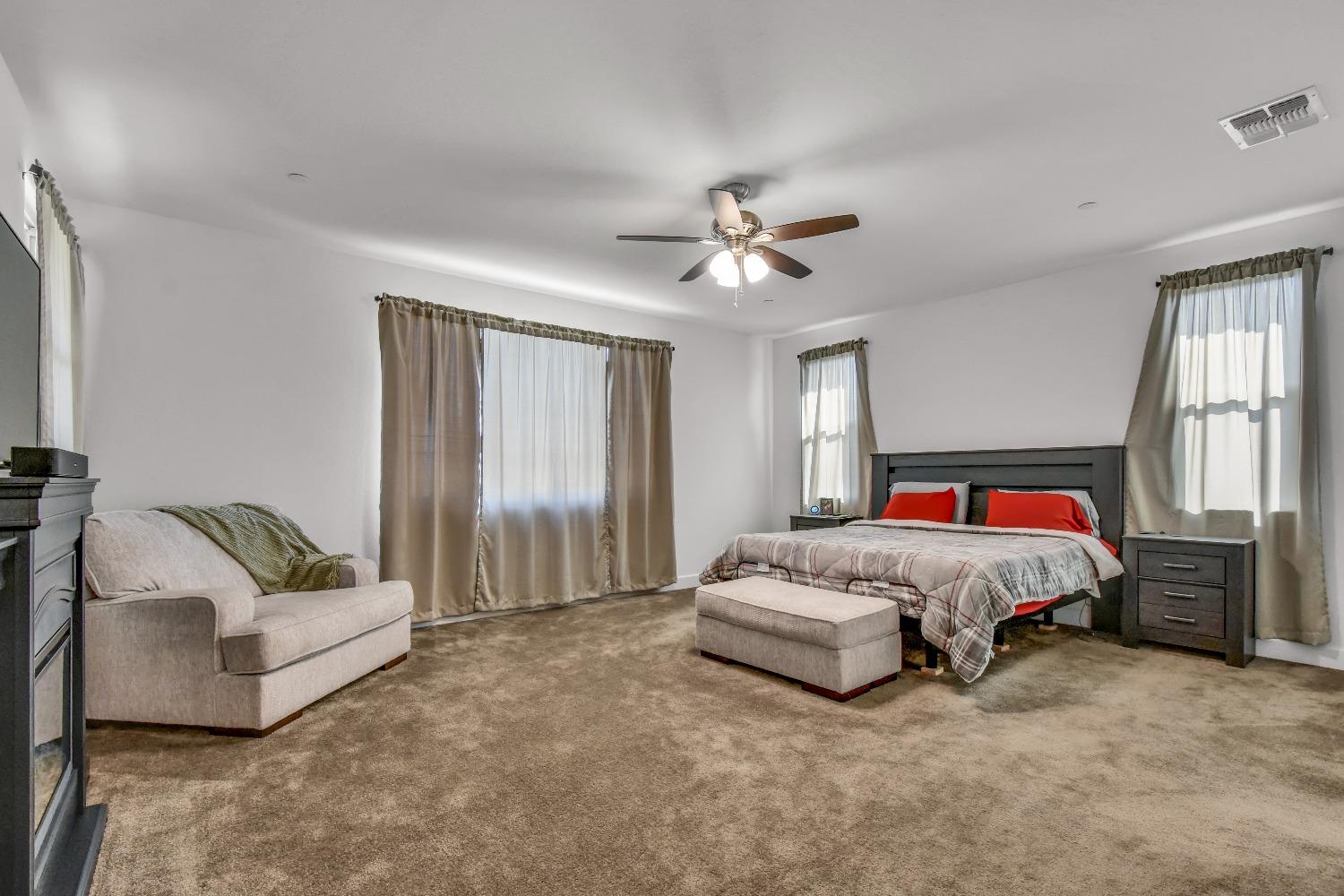 400 Ridge Creek Estates Way Dinuba, CA 93618 - Photo 28 of 49 a spacious bedroom with a bed and a couch