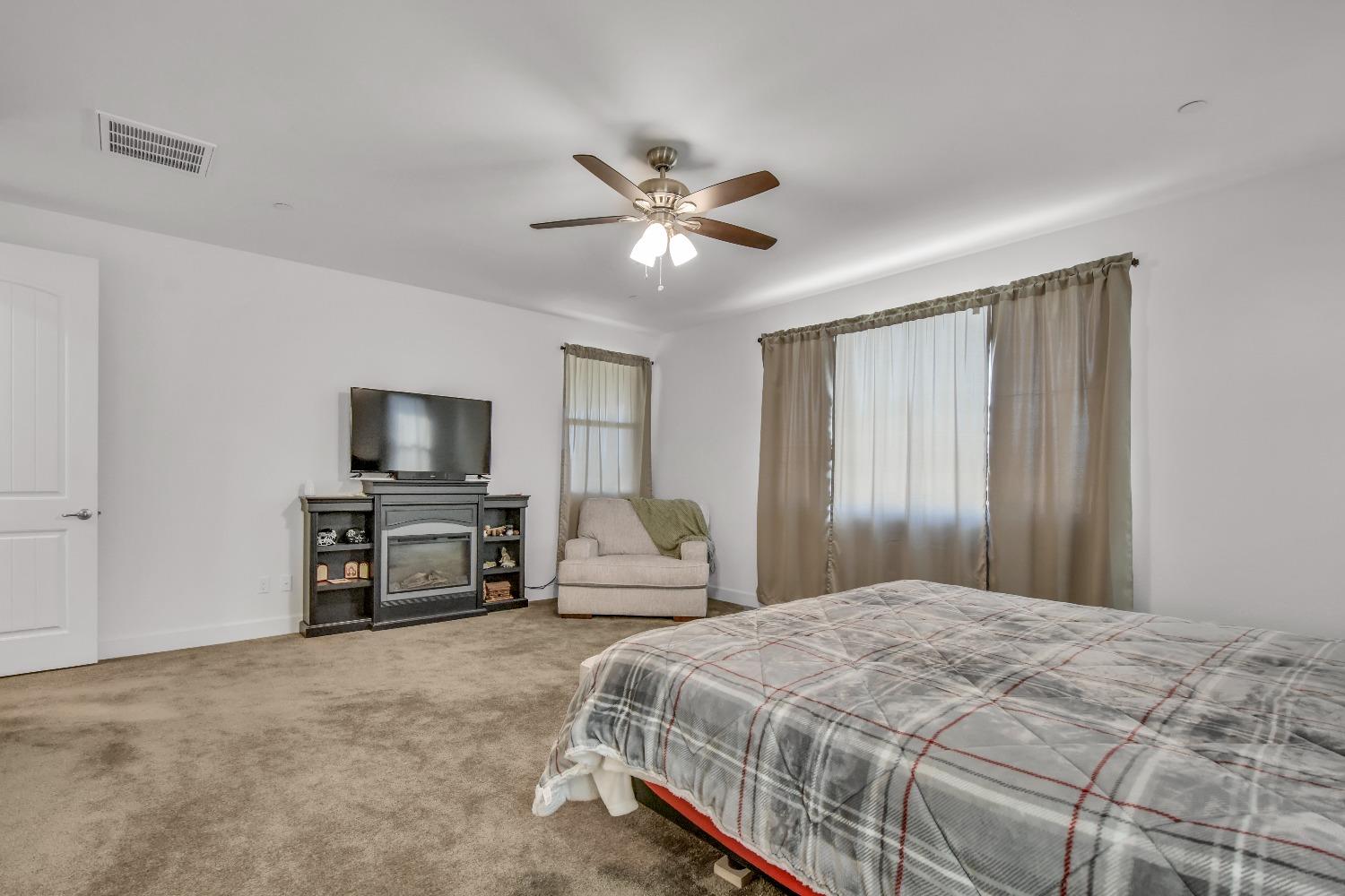 400 Ridge Creek Estates Way Dinuba, CA 93618 - Photo 30 of 49 a bedroom with a bed and a flat screen tv