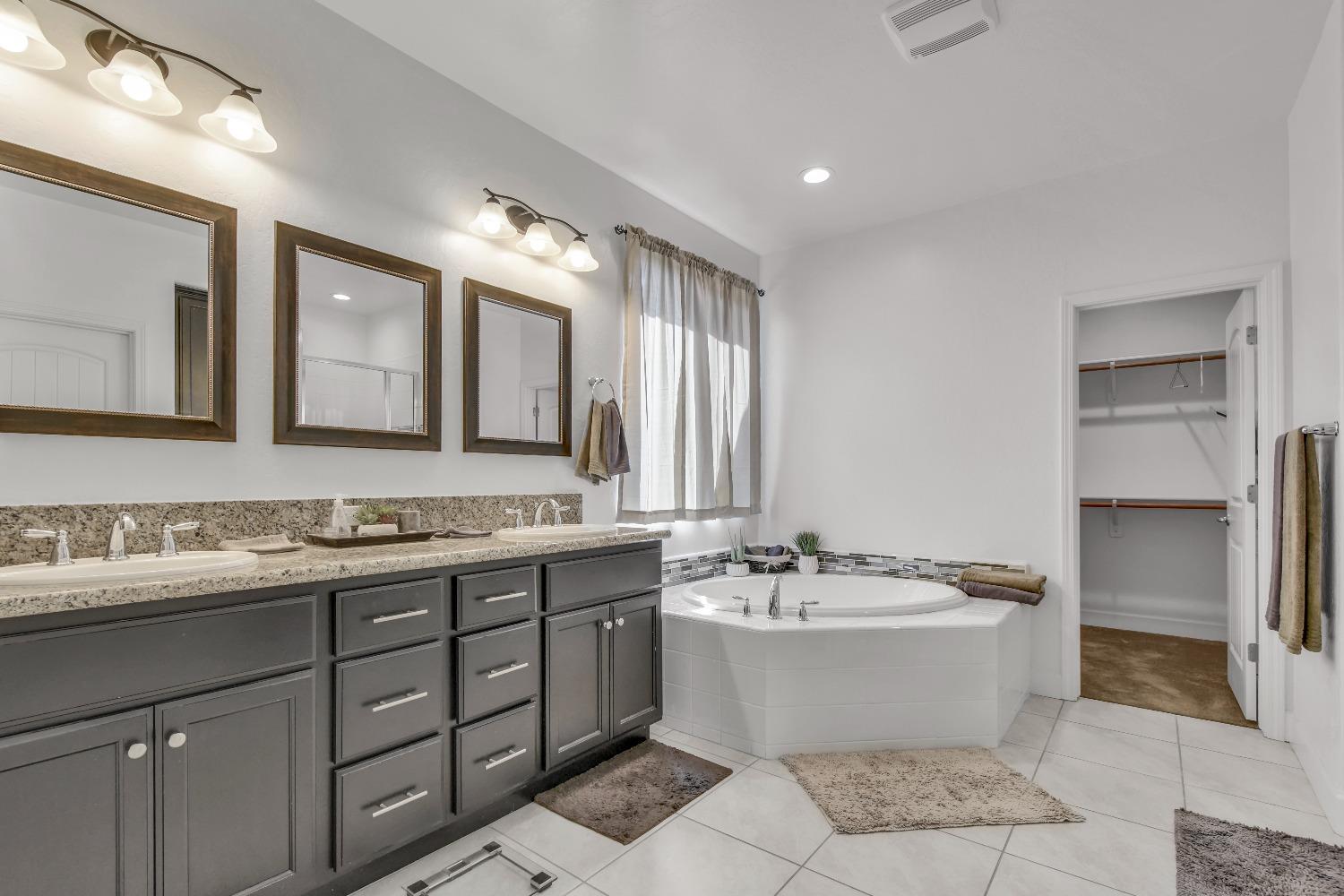 400 Ridge Creek Estates Way Dinuba, CA 93618 - Photo 31 of 49 a bathroom with a double vanity sink mirror and bathtub