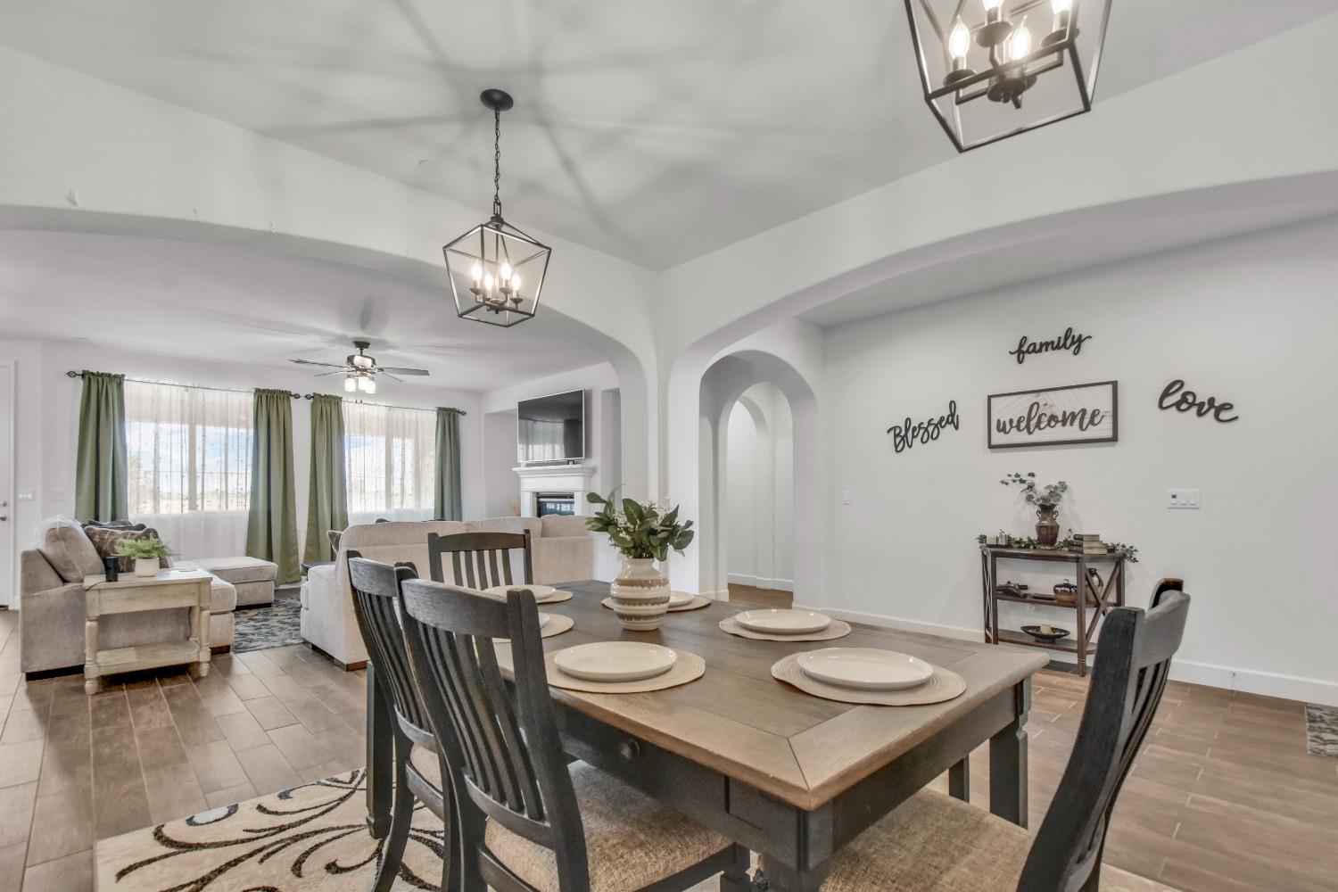 400 Ridge Creek Estates Way Dinuba, CA 93618 - Photo 7 of 49 a view of a dining room with furniture a chandelier and wooden floor