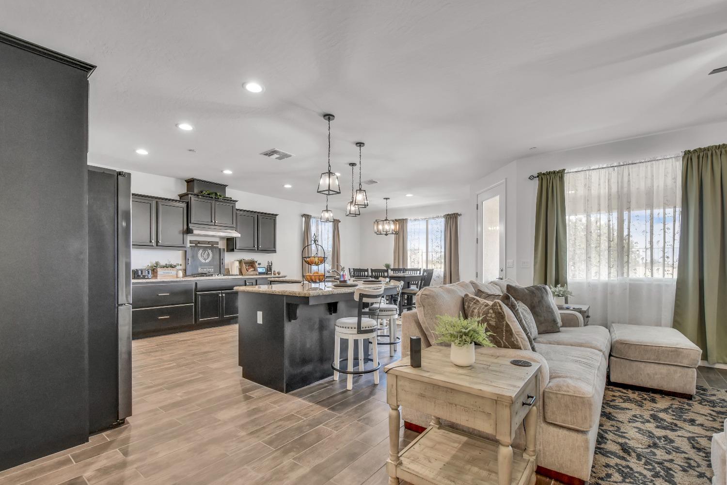 400 Ridge Creek Estates Way Dinuba, CA 93618 - Photo 9 of 49 a view of kitchen with kitchen island stainless steel appliances refrigerator stove dining table and chairs
