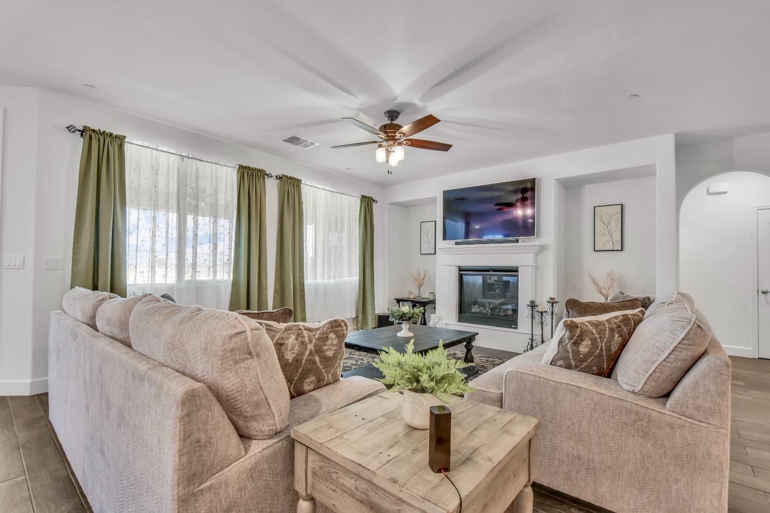 400 Ridge Creek Estates Way Dinuba, CA 93618 - Photo 10 of 49 a living room with furniture a fireplace and a large window