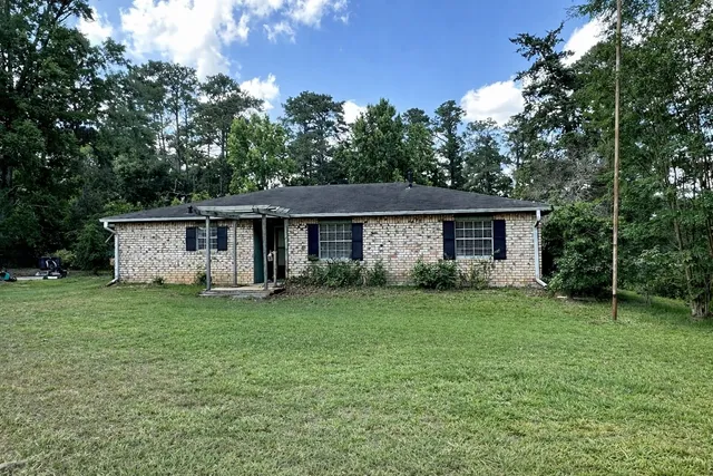 a front view of house with a garden