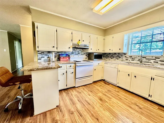 a kitchen with a sink window and cabinets