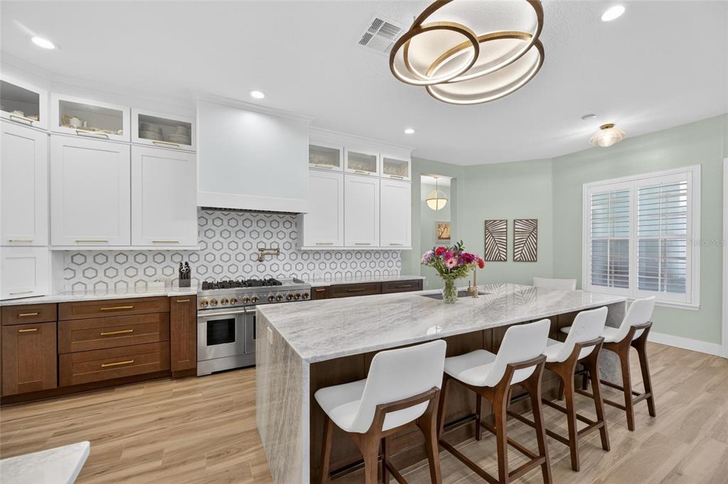 508 Islebay Drive Apollo Beach, FL 33572 - Photo 27 of 98 a kitchen with stainless steel appliances granite countertop a stove a sink dishwasher a dining table and chairs with wooden floor
