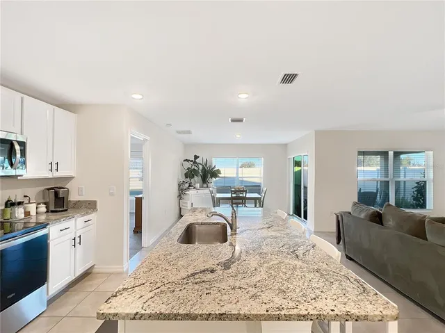 a living room with furniture and a kitchen view