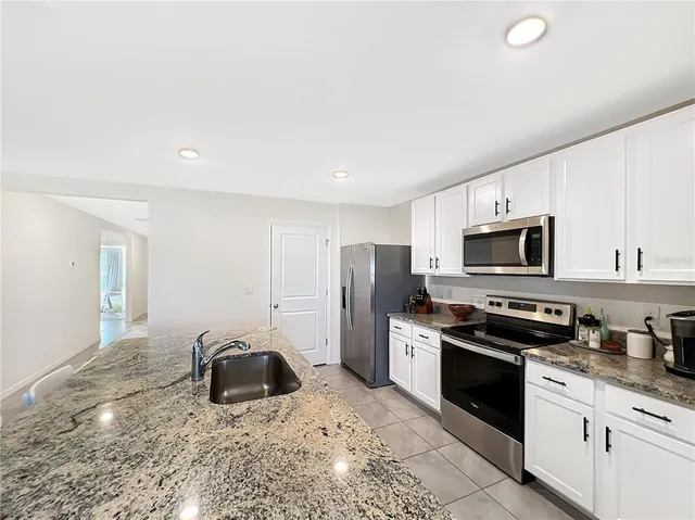 a kitchen with stainless steel appliances granite countertop a stove a sink and a refrigerator
