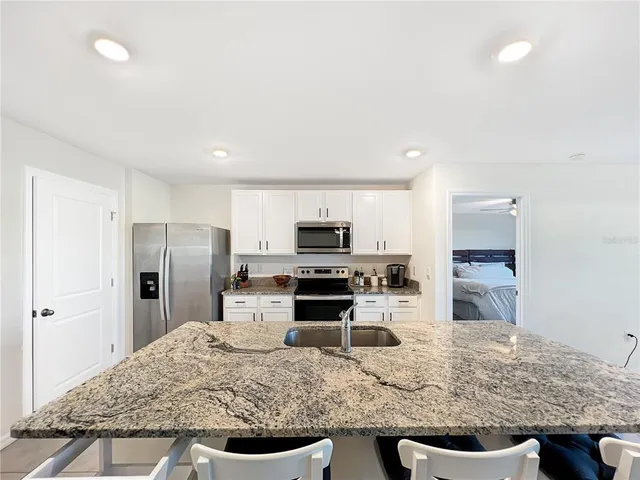a kitchen with a refrigerator and a stove top oven