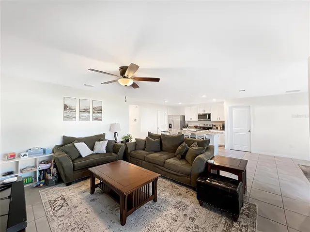 a living room with furniture and a black refrigerator