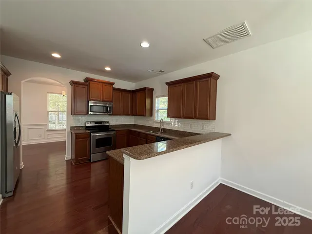 a kitchen with granite countertop a stove and a refrigerator