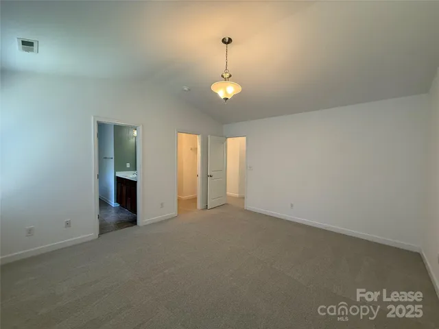 en empty room with windows and chandelier