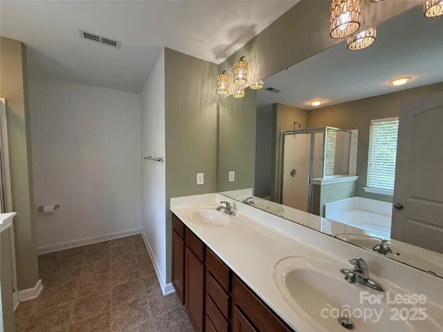 a spacious bathroom with a double vanity sink a large mirror and shower