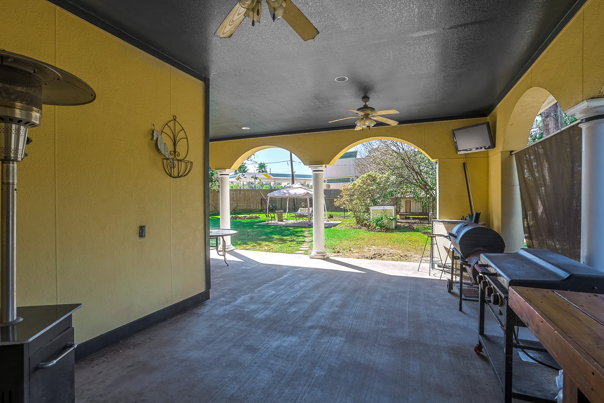 30119 West Geneva Drive Spring, TX 77386 - Photo 33 of 35 Expansive covered patio with graceful arches and dual ceiling fans — ideal for relaxing, grilling, or entertaining guests year-round