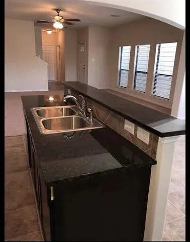 a view of a kitchen with a sink and chandelier