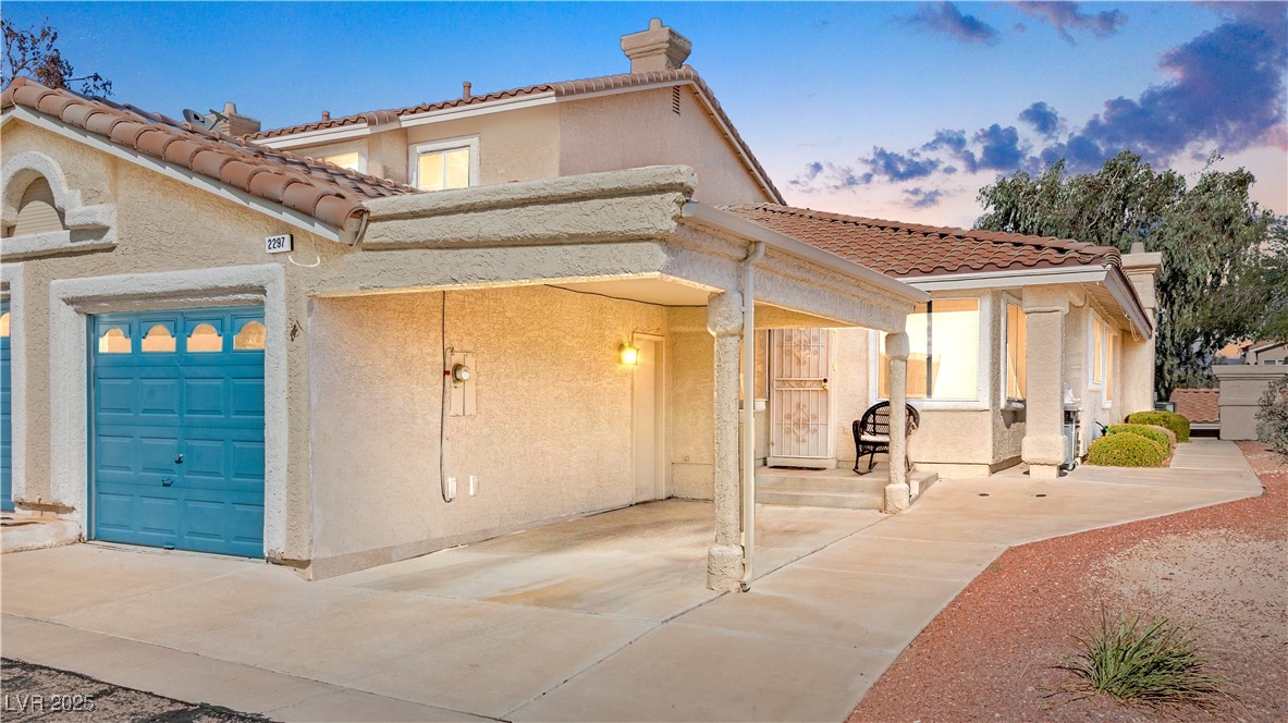 Mediterranean / spanish-style home with stucco siding, a tile roof, and concrete driveway