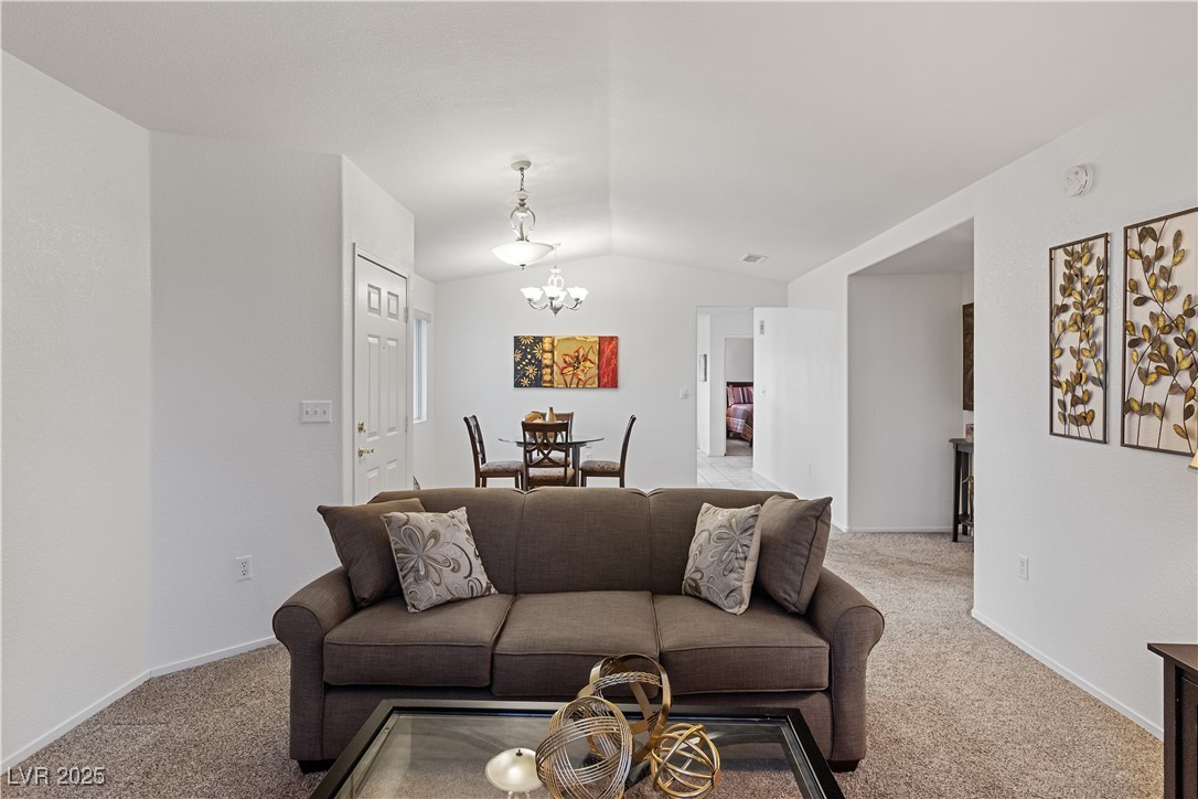 2297 Camel Mesa Drive Laughlin, NV 89029 - Photo 13 of 98 Living room featuring carpet floors, a chandelier, and vaulted ceiling