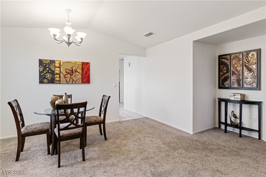 2297 Camel Mesa Drive Laughlin, NV 89029 - Photo 15 of 98 Dining room featuring a chandelier, light carpet, and lofted ceiling