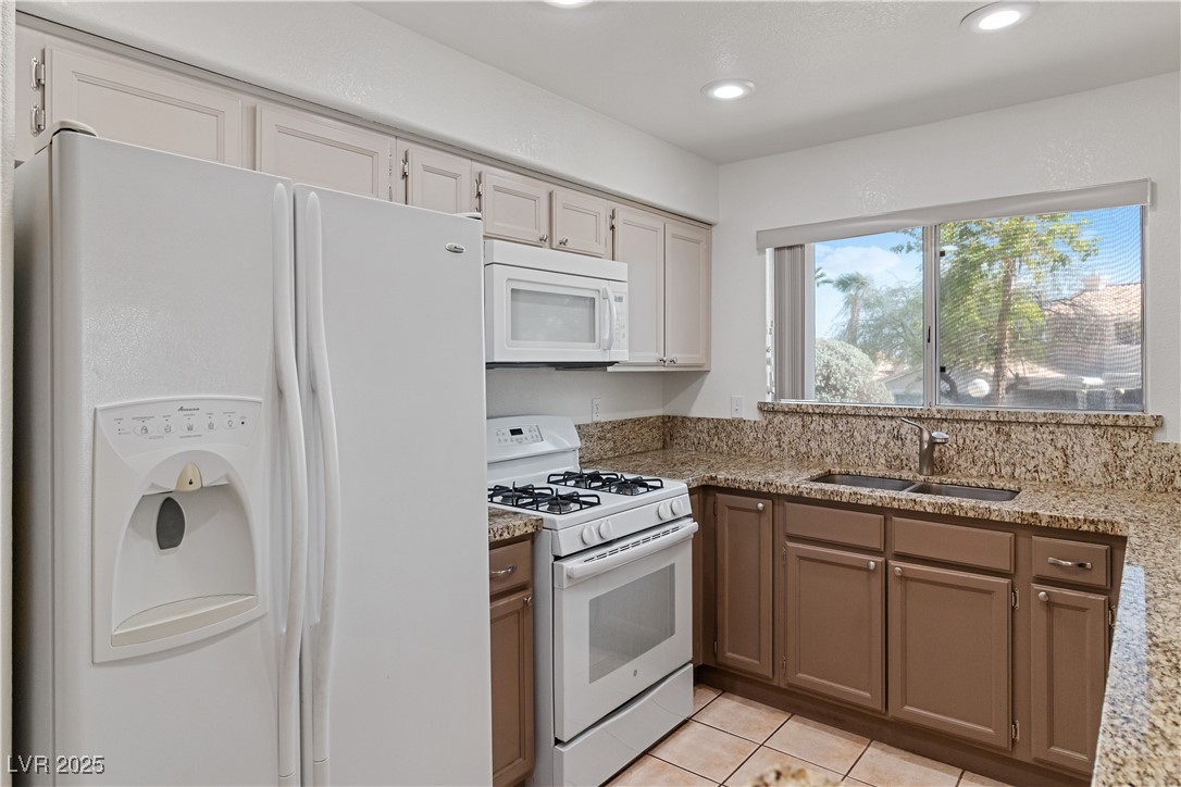 2297 Camel Mesa Drive Laughlin, NV 89029 - Photo 33 of 98 Kitchen featuring white appliances, light tile patterned floors, light stone countertops, recessed lighting, and white cabinets