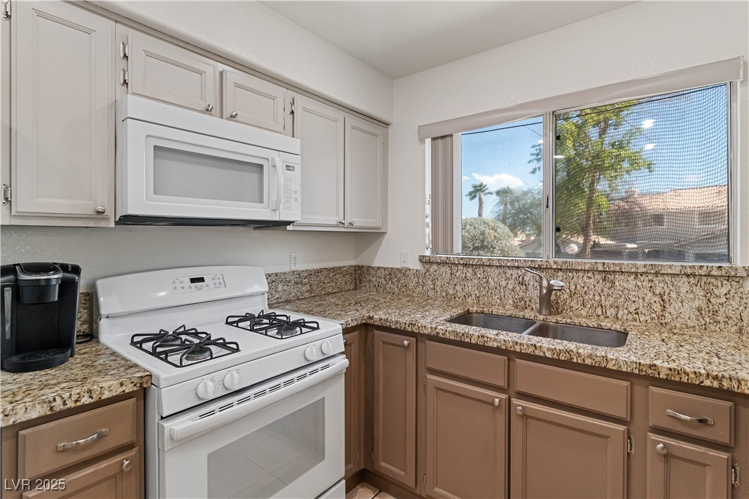 2297 Camel Mesa Drive Laughlin, NV 89029 - Photo 34 of 98 Kitchen featuring white appliances, light stone counters, and white cabinets