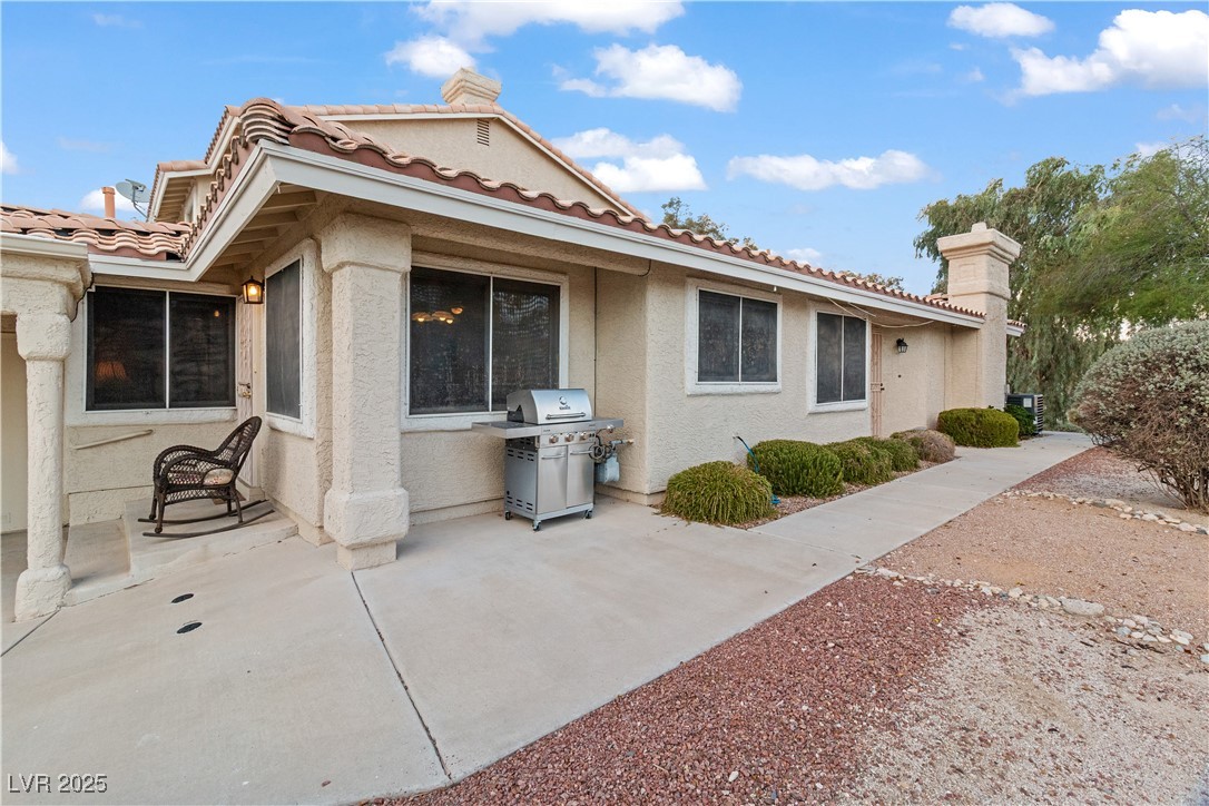 2297 Camel Mesa Drive Laughlin, NV 89029 - Photo 57 of 98 Side view of house featuring stucco siding, a tiled roof, and a patio area