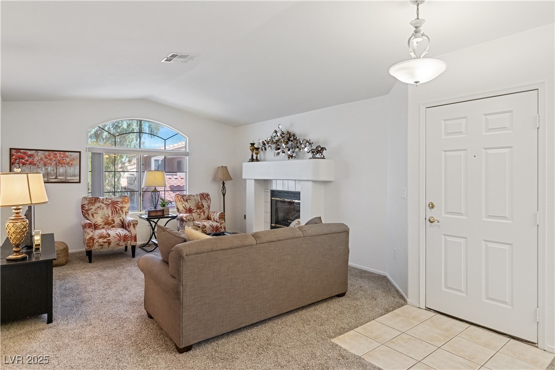 2297 Camel Mesa Drive Laughlin, NV 89029 - Photo 6 of 98 Living area featuring light colored carpet, a fireplace, lofted ceiling, and light tile patterned flooring