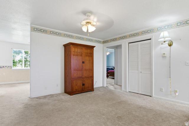 435 East 4th North Preston, ID 83263 - Photo 8 of 26 Carpeted interior space featuring a ceiling fan, wall sconce lighting, and a bi-fold louvered door closet
