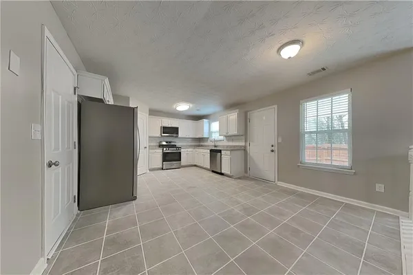 a view of a kitchen with microwave and refrigerator