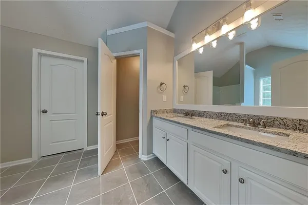 a spacious bathroom with a granite countertop sink a mirror and a