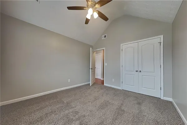 a view of an empty room and chandelier fan