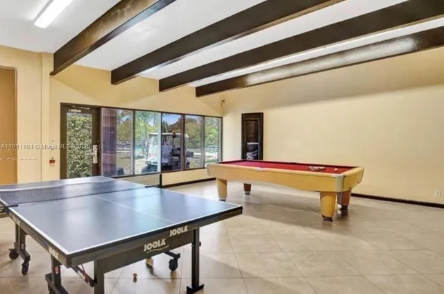 a room with pool table and windows