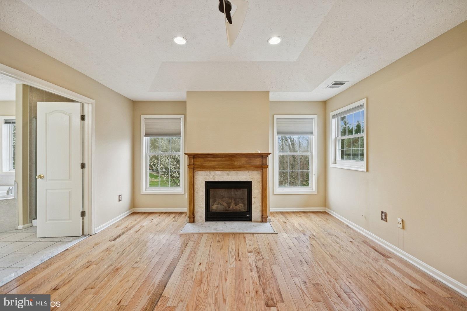 6965 Hawkins Gate Road La Plata, MD 20646 - Photo 35 of 55 a view of an empty room with wooden floor fireplace and a window