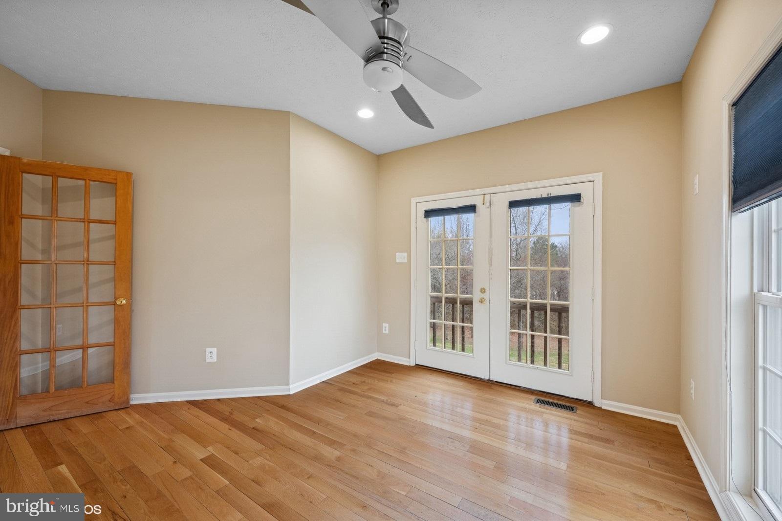 6965 Hawkins Gate Road La Plata, MD 20646 - Photo 9 of 55 an empty room with wooden floor cabinet and windows