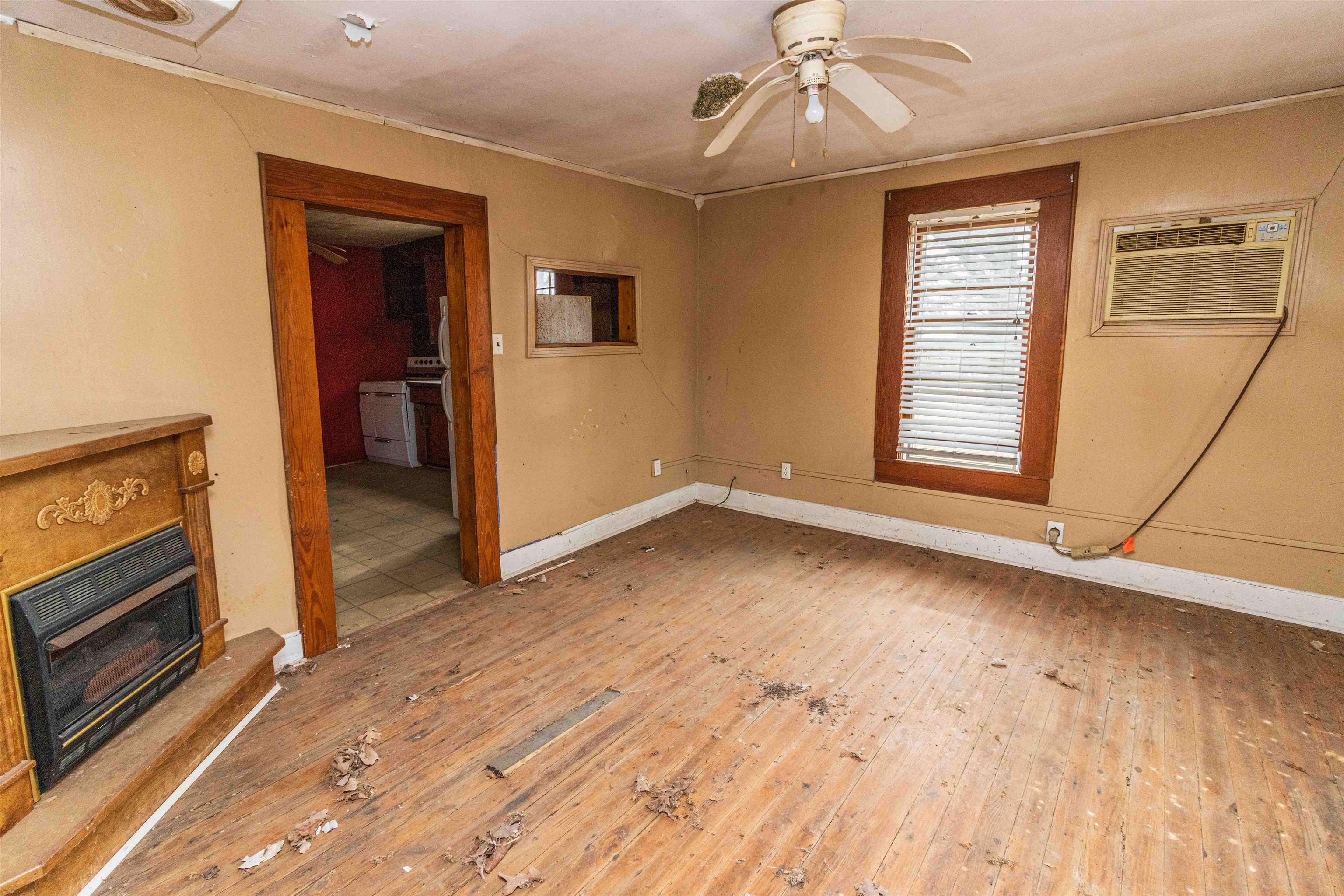 4850 Pleasant Site Road Selmer, TN 38375 - Photo 5 of 18 an empty room with wooden floor cabinet and windows