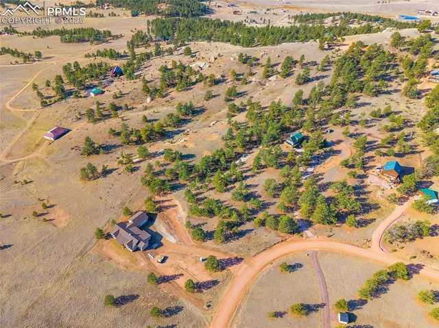 an aerial view of a house with a lot of trees all around