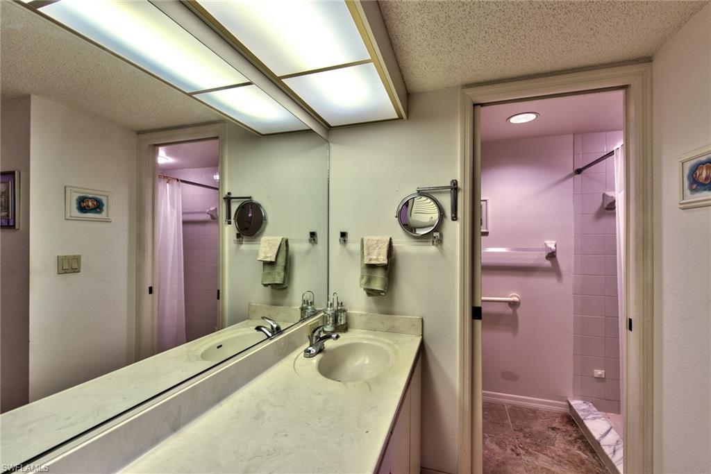 14730 Eagle Ridge Drive, Unit 122 Fort Myers, FL 33912 - Photo 13 of 27 a bathroom with a sink a vanity and a mirror