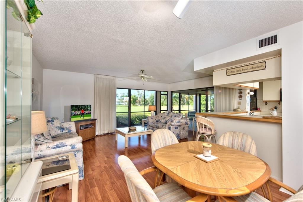 14730 Eagle Ridge Drive, Unit 122 Fort Myers, FL 33912 - Photo 3 of 27 a living room with furniture a large window and wooden floor