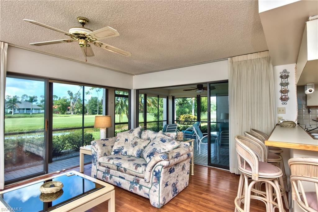 14730 Eagle Ridge Drive, Unit 122 Fort Myers, FL 33912 - Photo 4 of 27 a living room with furniture and a floor to ceiling window